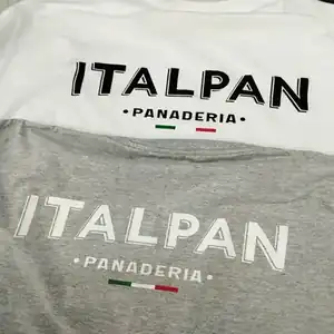Serigrafía profesional en remeras - Uniformes para negocio Remeras serigrafía blanca con texto ITALPAN PANADERIA y bandera
